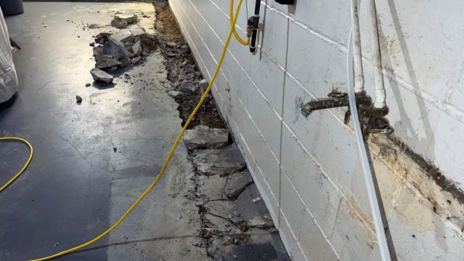  A worker repairs a wall using a yellow wire, highlighting the ongoing maintenance process.