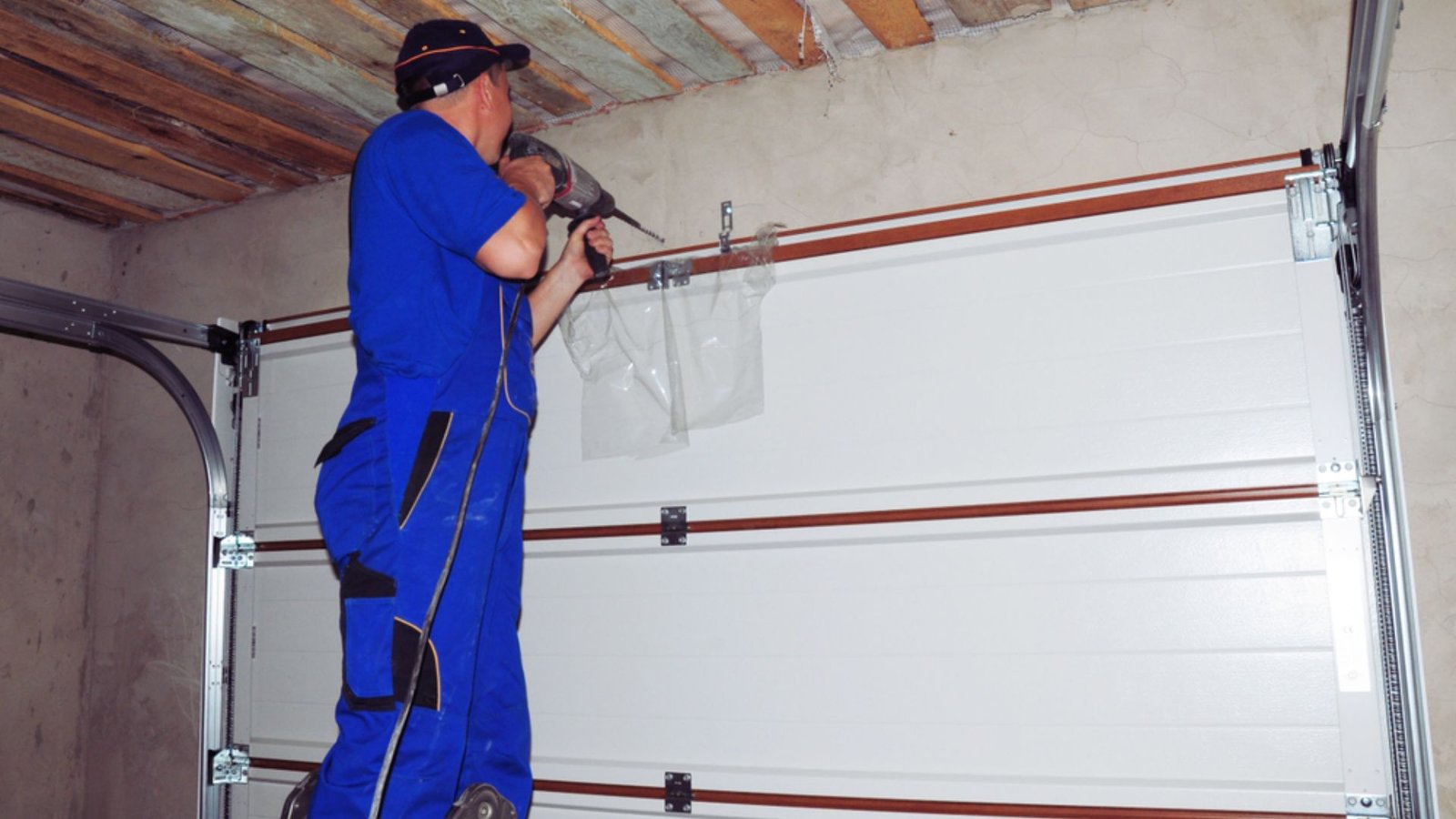 A technician repairing a garage door in Maryland, showcasing tools and parts used for the service.