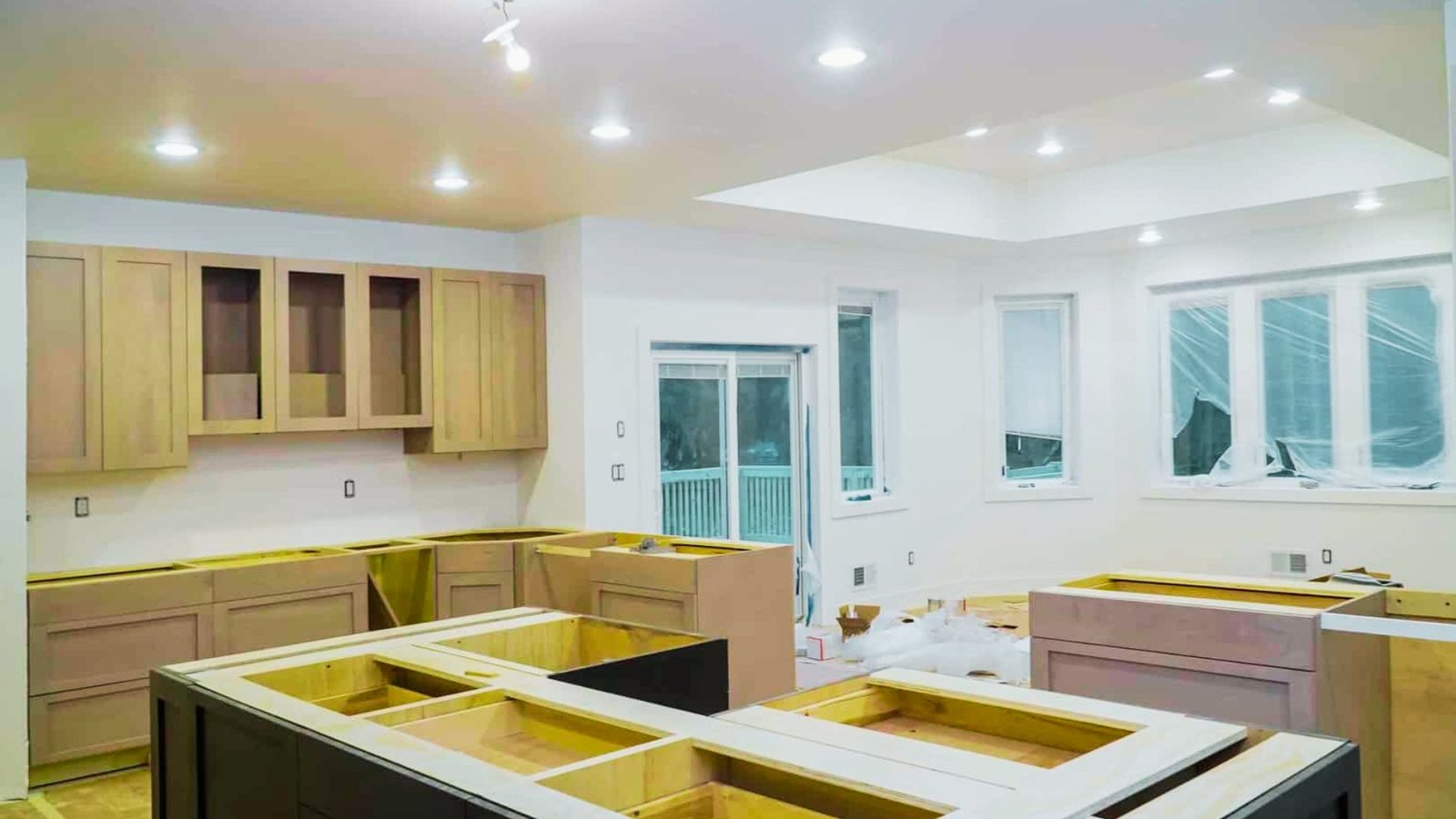 A kitchen under construction, featuring cabinets and countertops being installed.